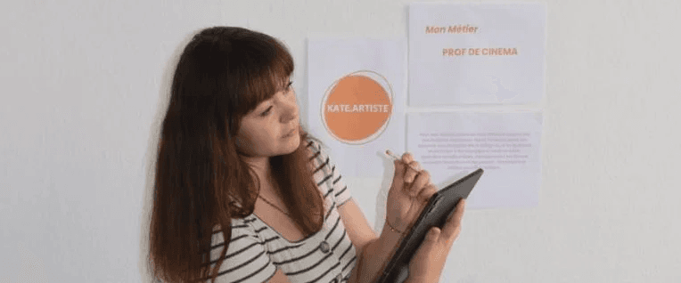 femme utilisant une tablette devant un mur avec un texte sur le cinéma et un logo kate artiste